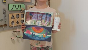 na zdjęciu dziewczynka pozuje z eko zabawką wykonaną z surowców wtórnych