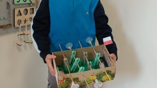 na zdjęciu chłopiec pozuje do zdjęcia z eko zabawką wykonaną z surowców wtórnych