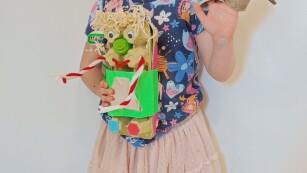 na zdjęciu dziewczynka z eko zabawką wykonaną z surowców wtórnych