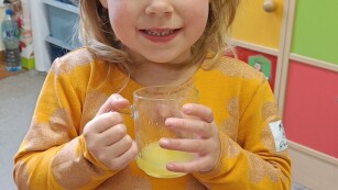 dziewczynka pije kwaśny sok pomarańczowy