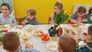 dzieci częstują się potrawami przygotowanymi na śniadanie wielkanocne