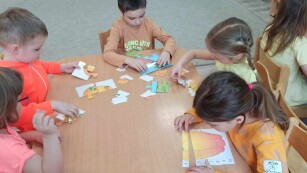 Dzieci układają puzzle przy stoliku