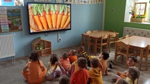 Dzieci oglądają film edukacyjny na temat marchewki