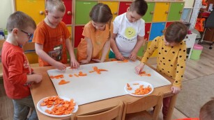 Dzieci układają obrazek z użyciem marchewki