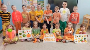 Dzieci z grupy Zajączki ubrane na pomarańczowo pozują do zdjęcia