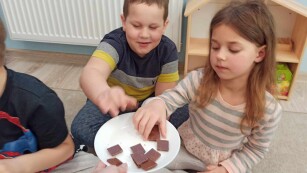 Dzieci częstują się kawałkami czekolady