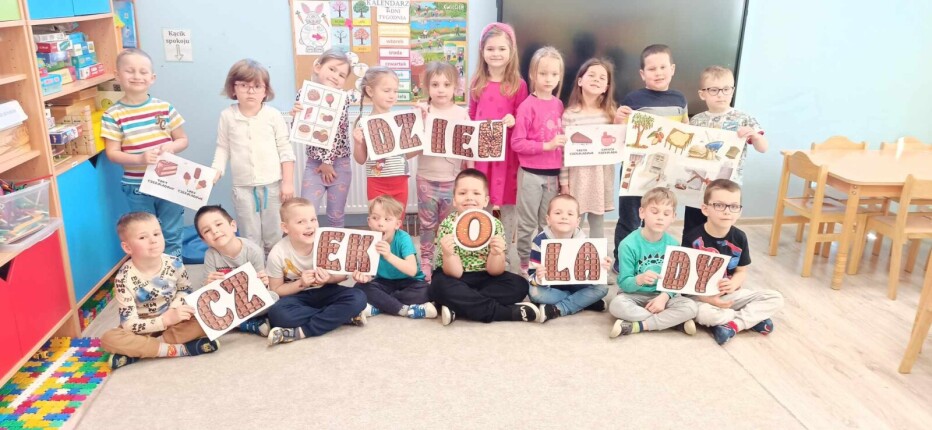 Cała grupa dzieci z grypy Zajączki pozuje z napisem  dzień czekolady